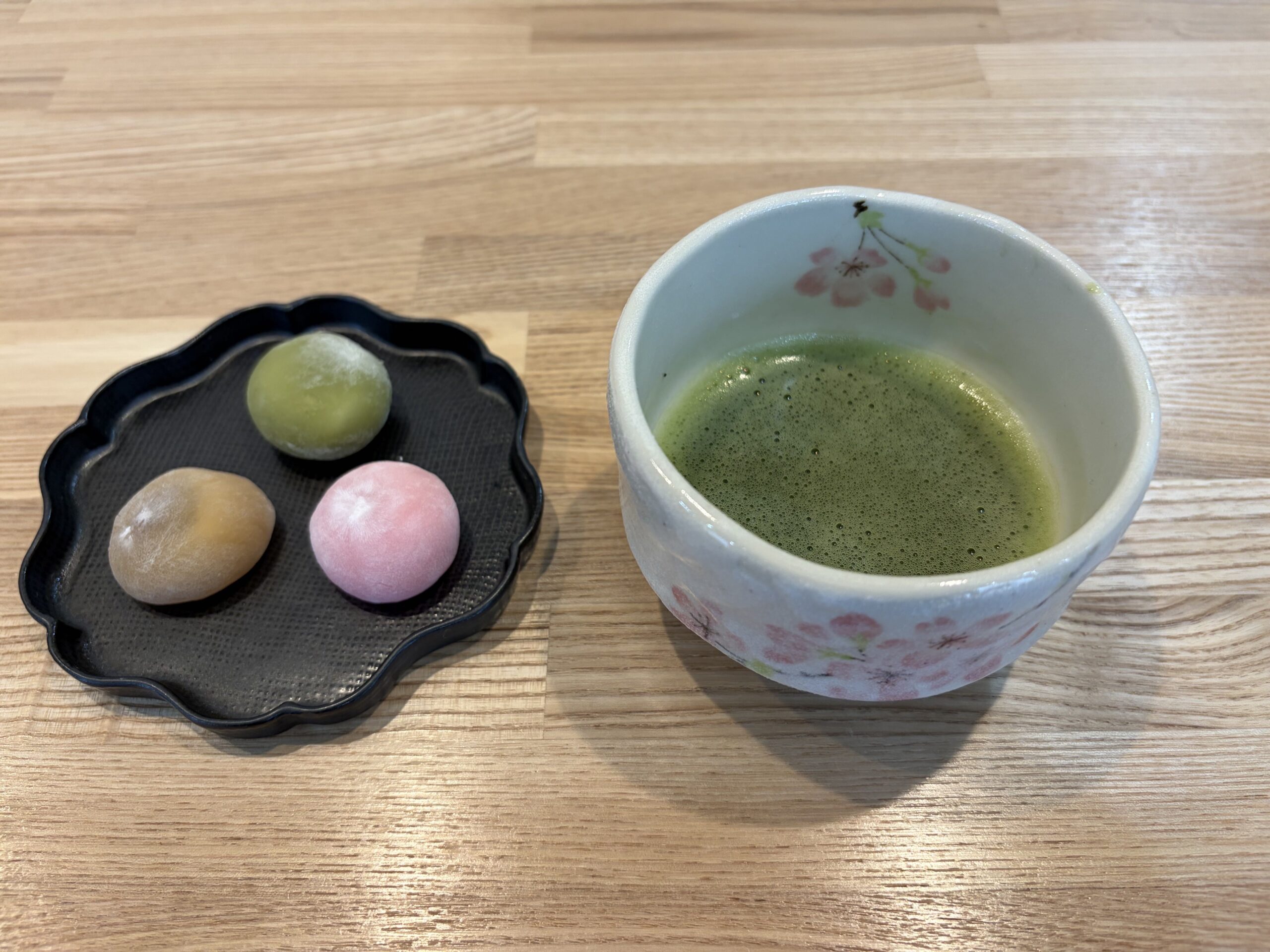 木のテーブルに置かれた抹茶の茶碗